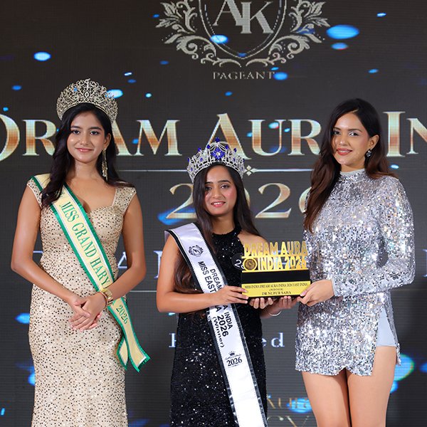 Dr. Nupur Saha wearing her crown and sash while holding the Dream Aura India 2026 trophy during the award ceremony.