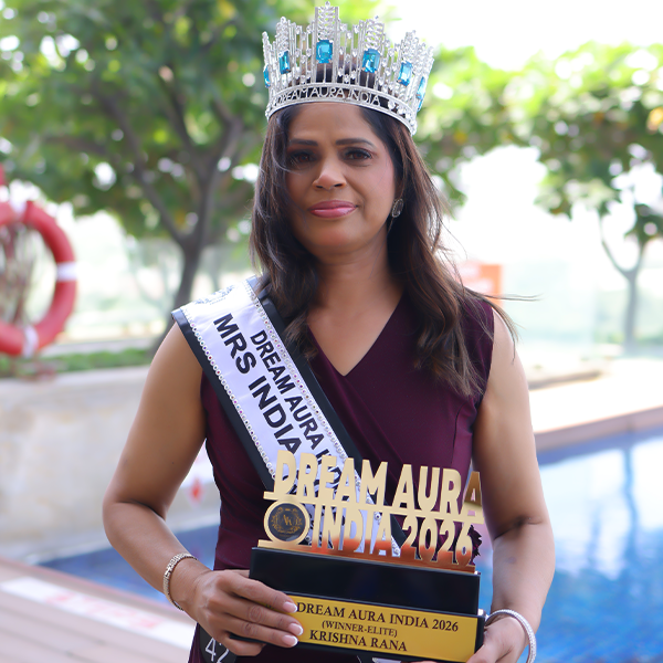 Krishna Rana poses outdoors wearing her crown and sash while holding the trophy as Mrs Dream Aura India Elite Winner 2026.