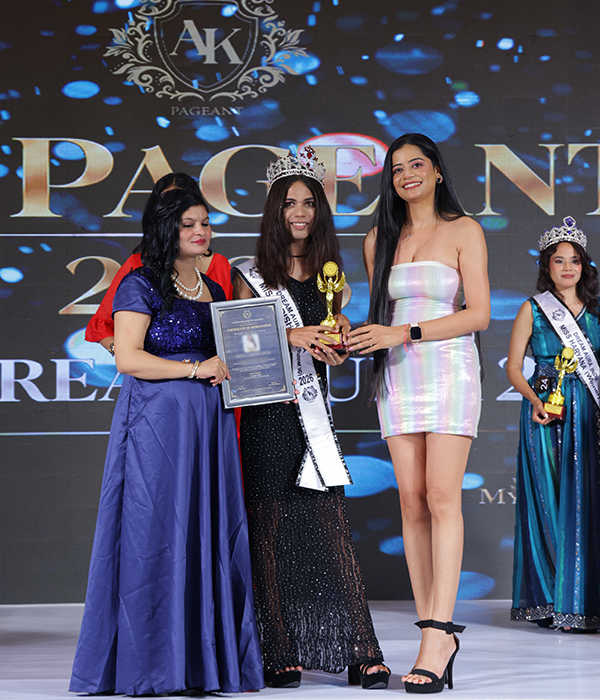 Harshita Bhargava wearing her crown and sash while holding the Dream Aura India 2026 trophy as the Madhya Pradesh Winner.