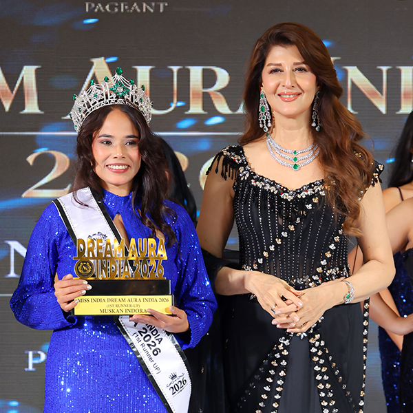 Muskaan Indora, First Runner-Up of Miss Dream Aura India 2026, wearing a blue embellished gown, crown, and sash while holding her award beside a celebrity guest at the pageant event.