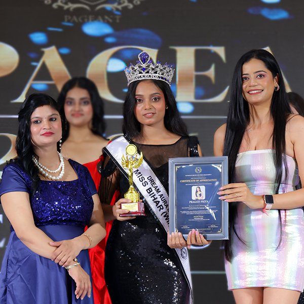 Pragati Priya wearing her crown and sash while holding a trophy and certificate at the Dream Aura India 2026 award ceremony.