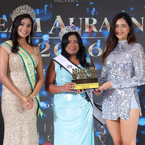 Ruksana wearing her crown and sash while holding a trophy and certificate at the Dream Aura India 2026 award ceremony.
